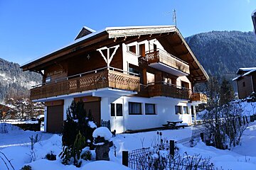 A house with a balcony is covered in snow