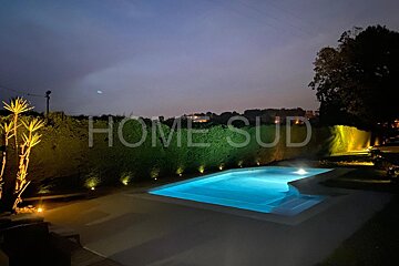 A large swimming pool is surrounded by a fence that says home sud