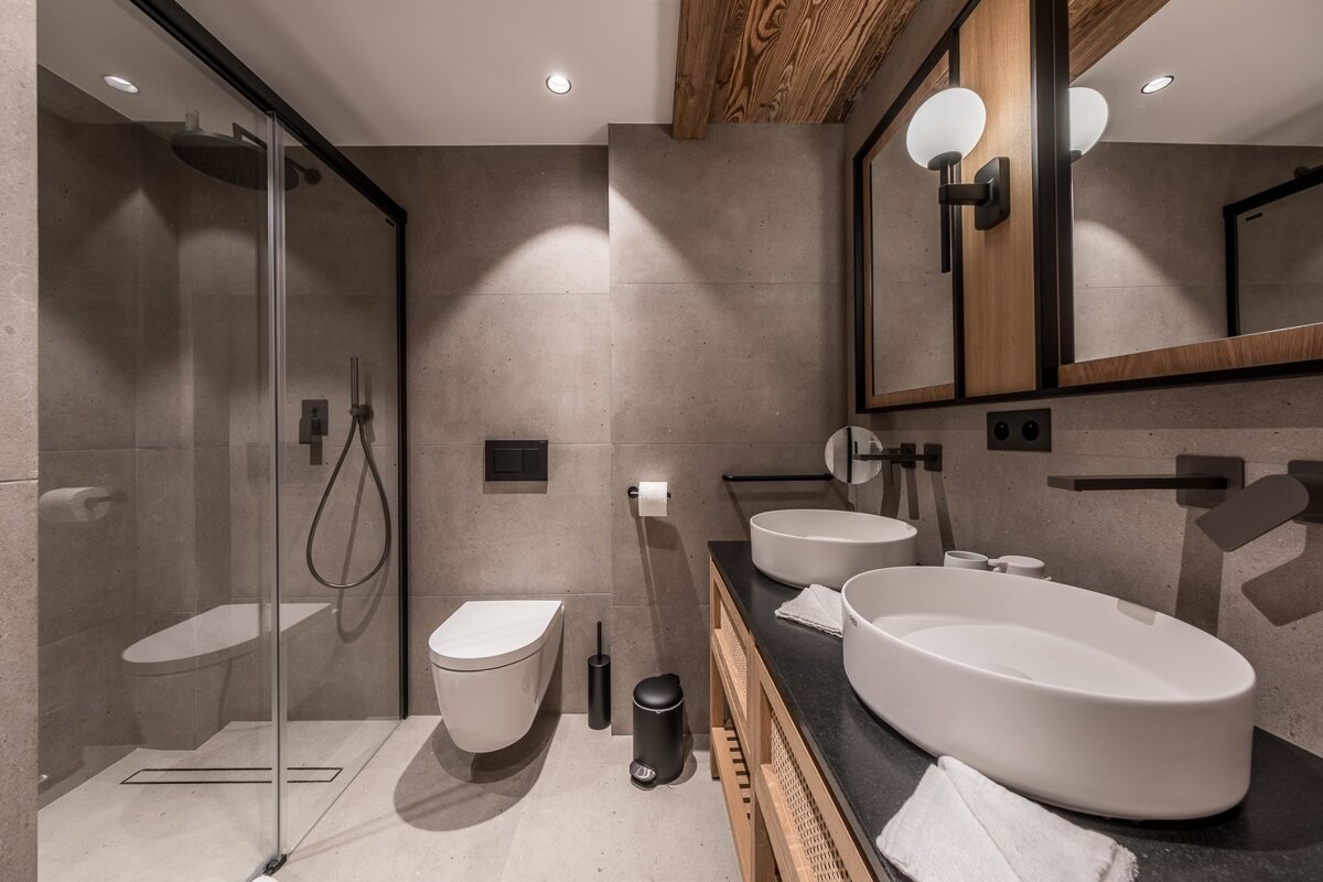 A bathroom with two sinks and a toilet