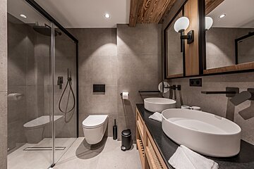 A bathroom with two sinks and a toilet