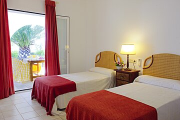 A bedroom with two beds and a sliding glass door