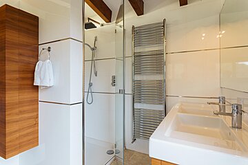 A bathroom with two sinks and a towel rack