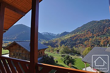 A balcony with a view of mountains and a house that says petite property