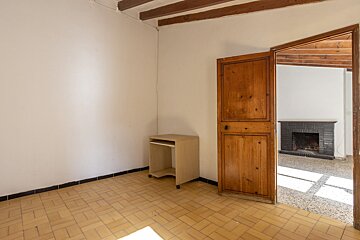 An empty room with a wooden door leading to a fireplace