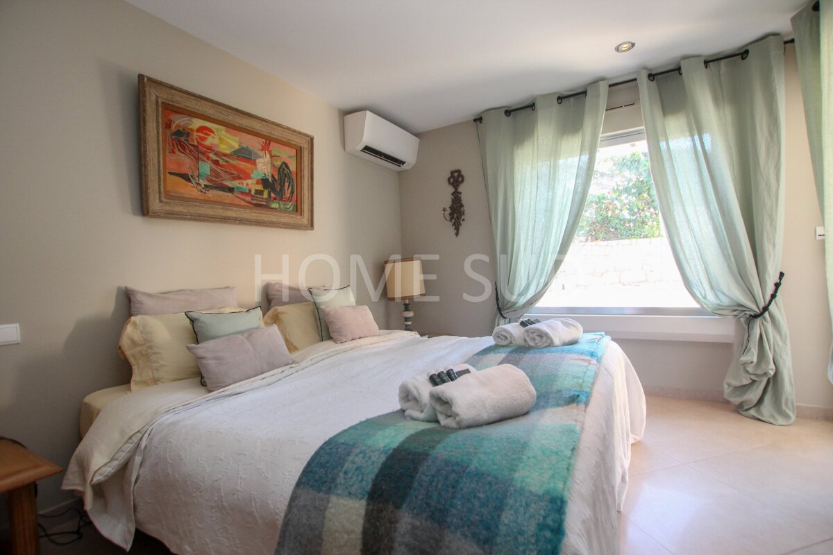 A bedroom with a large bed and a picture above it that says home