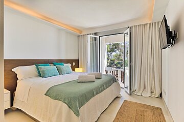 A bedroom with a large bed and a flat screen tv