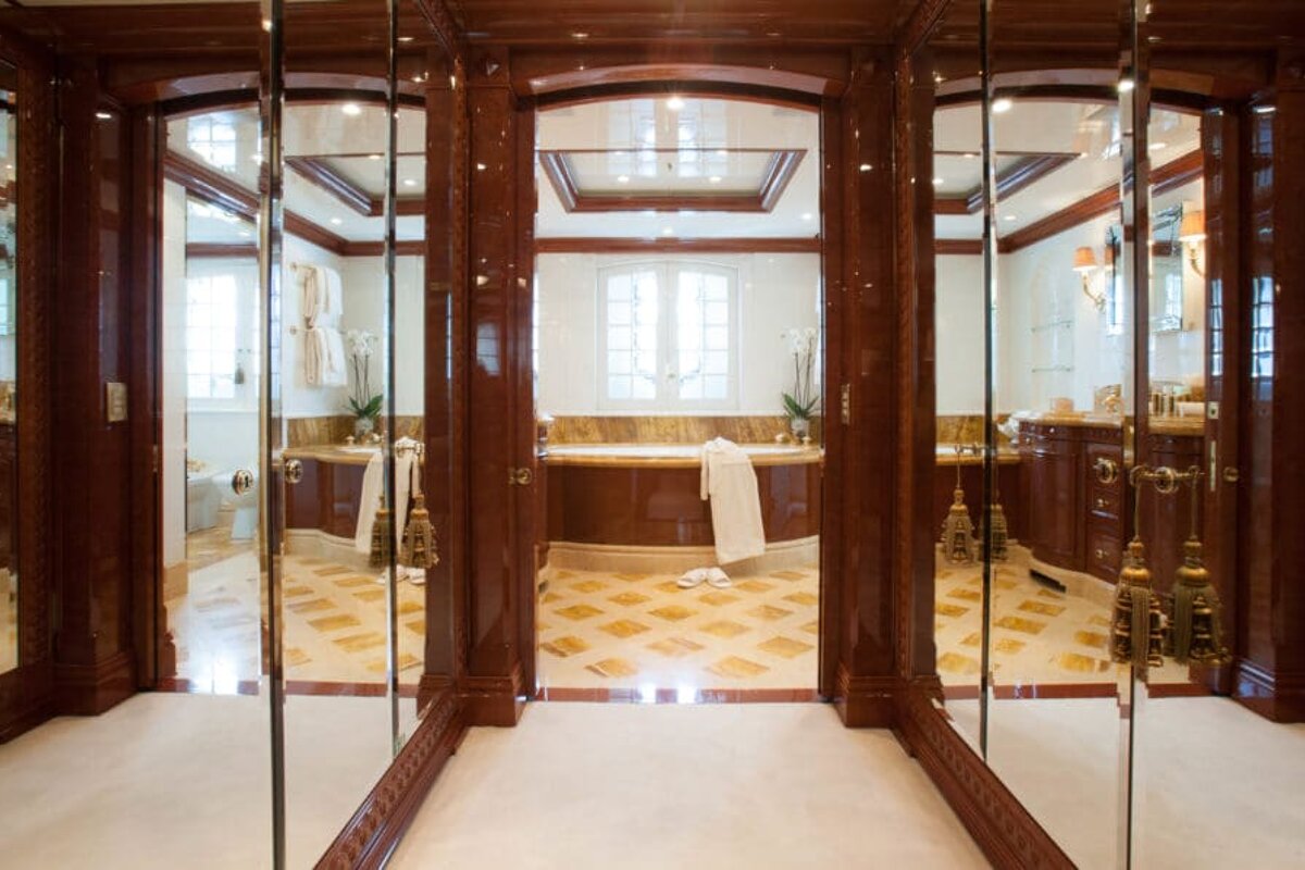 A bathroom with a bathtub and mirrors on the wall