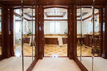 A bathroom with a bathtub and mirrors on the wall