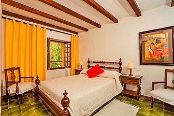 A bedroom with a bed and a painting on the wall