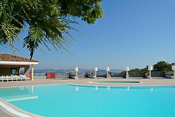 A large swimming pool with a gazebo in the background