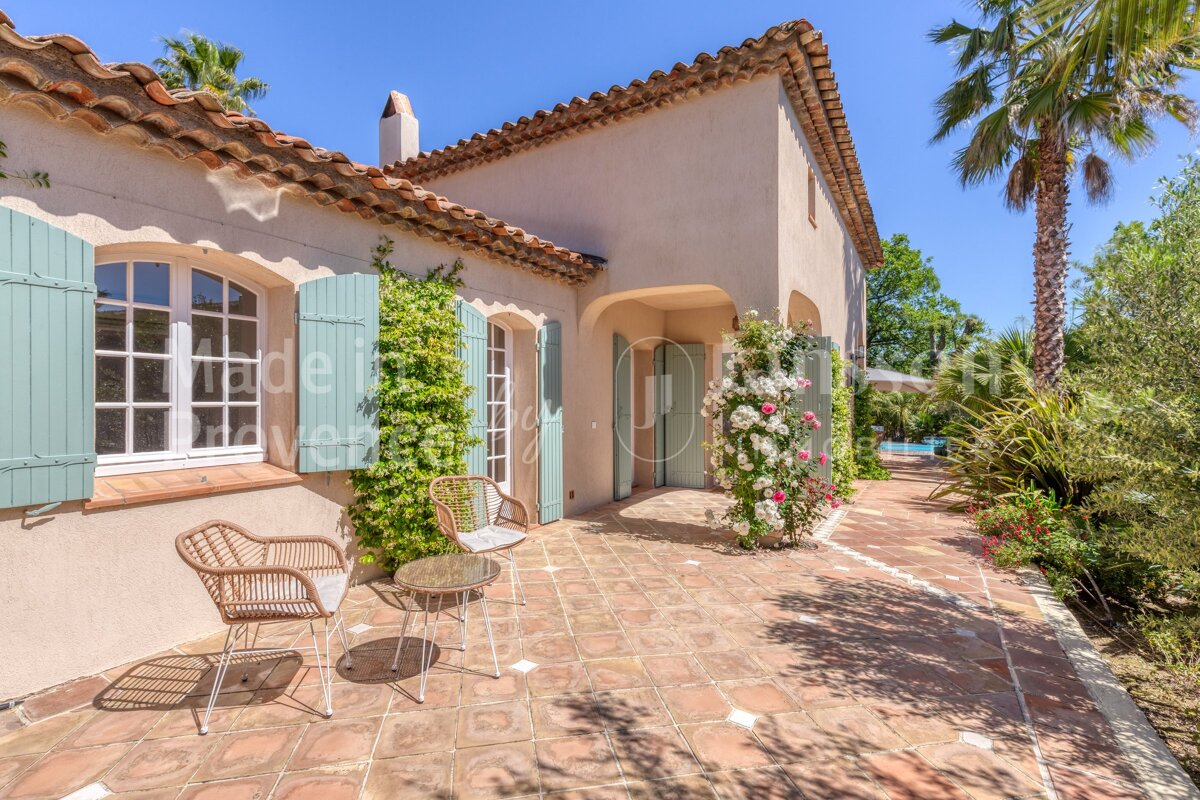 A patio with chairs and a table in front of a house that says made in france