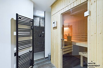 A white management photo of a sauna and shower