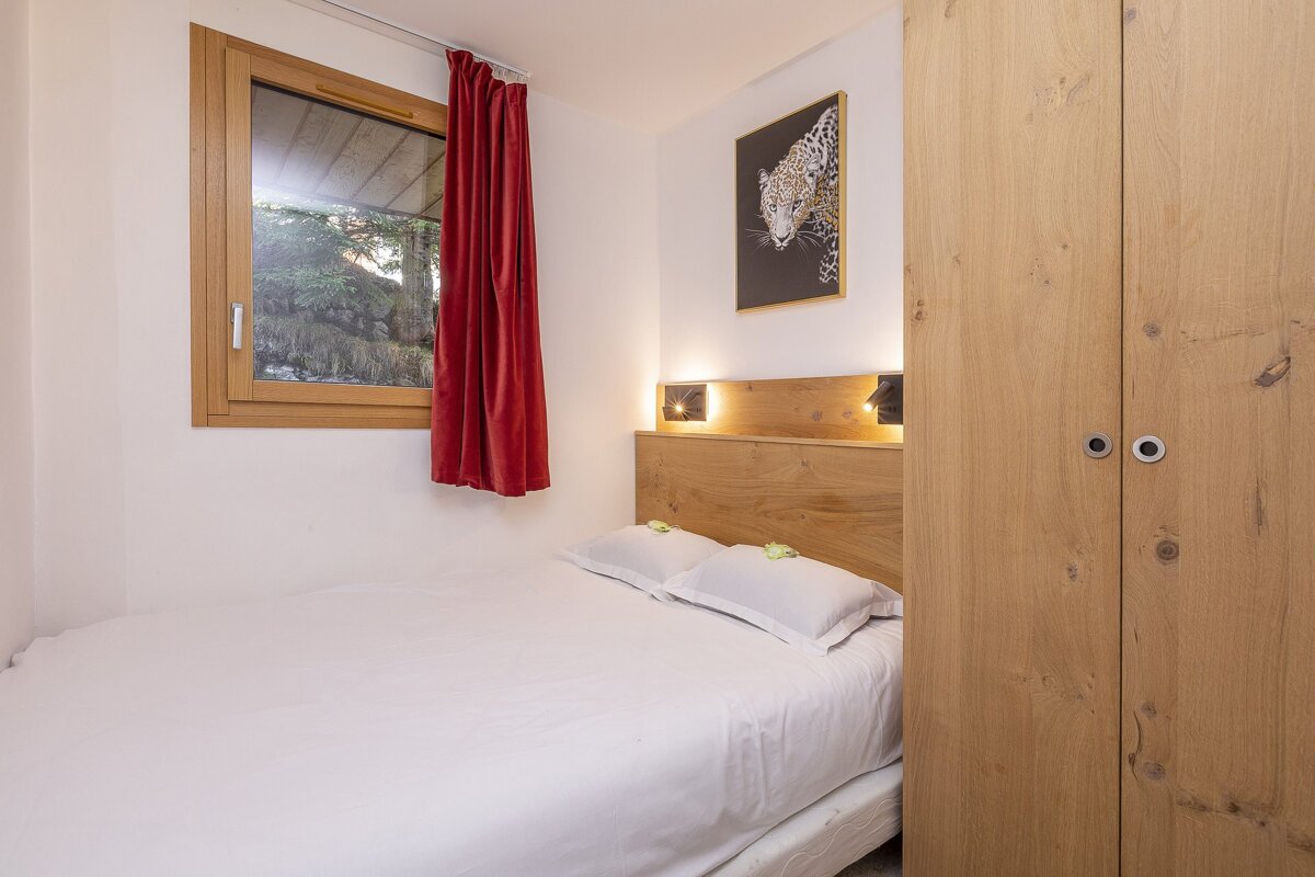 A bedroom with a bed and a picture of a leopard on the wall
