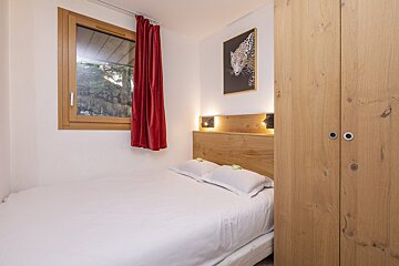 A bedroom with a bed and a picture of a leopard on the wall
