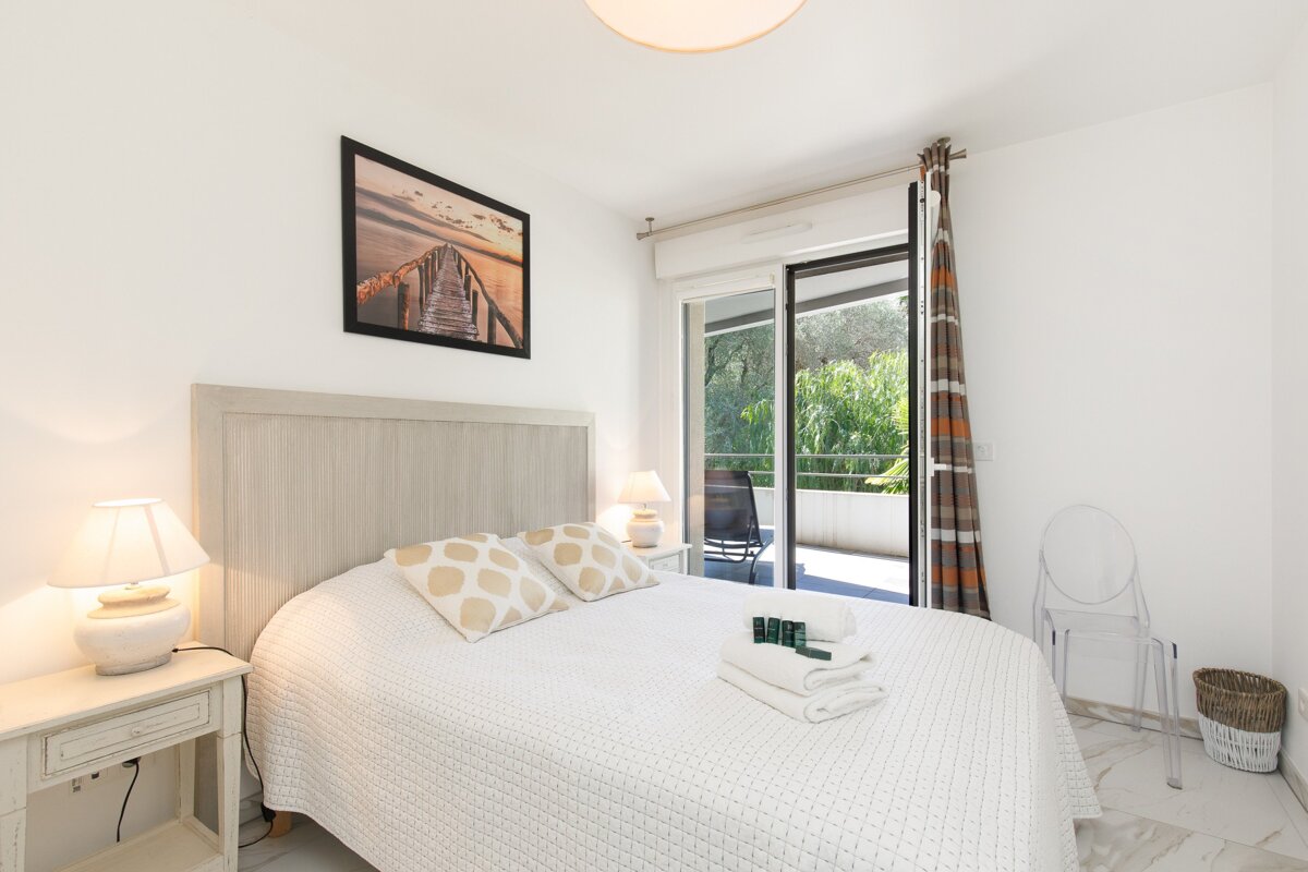 A bedroom with a sliding glass door leading to a balcony