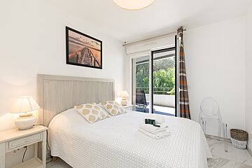 A bedroom with a sliding glass door leading to a balcony