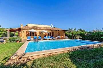 A house with a large swimming pool in front of it