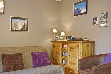 A living room with pictures on the wall and a couch