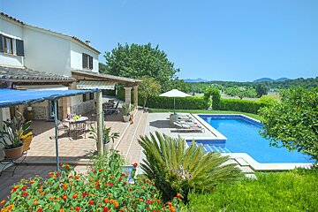 A house with a large swimming pool in front of it