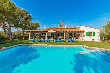 A house with a large swimming pool in front of it