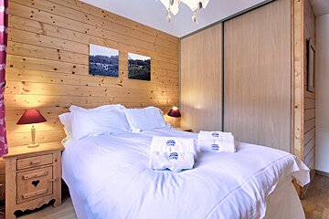 A bedroom with a bed and two towels with the word hotel on them