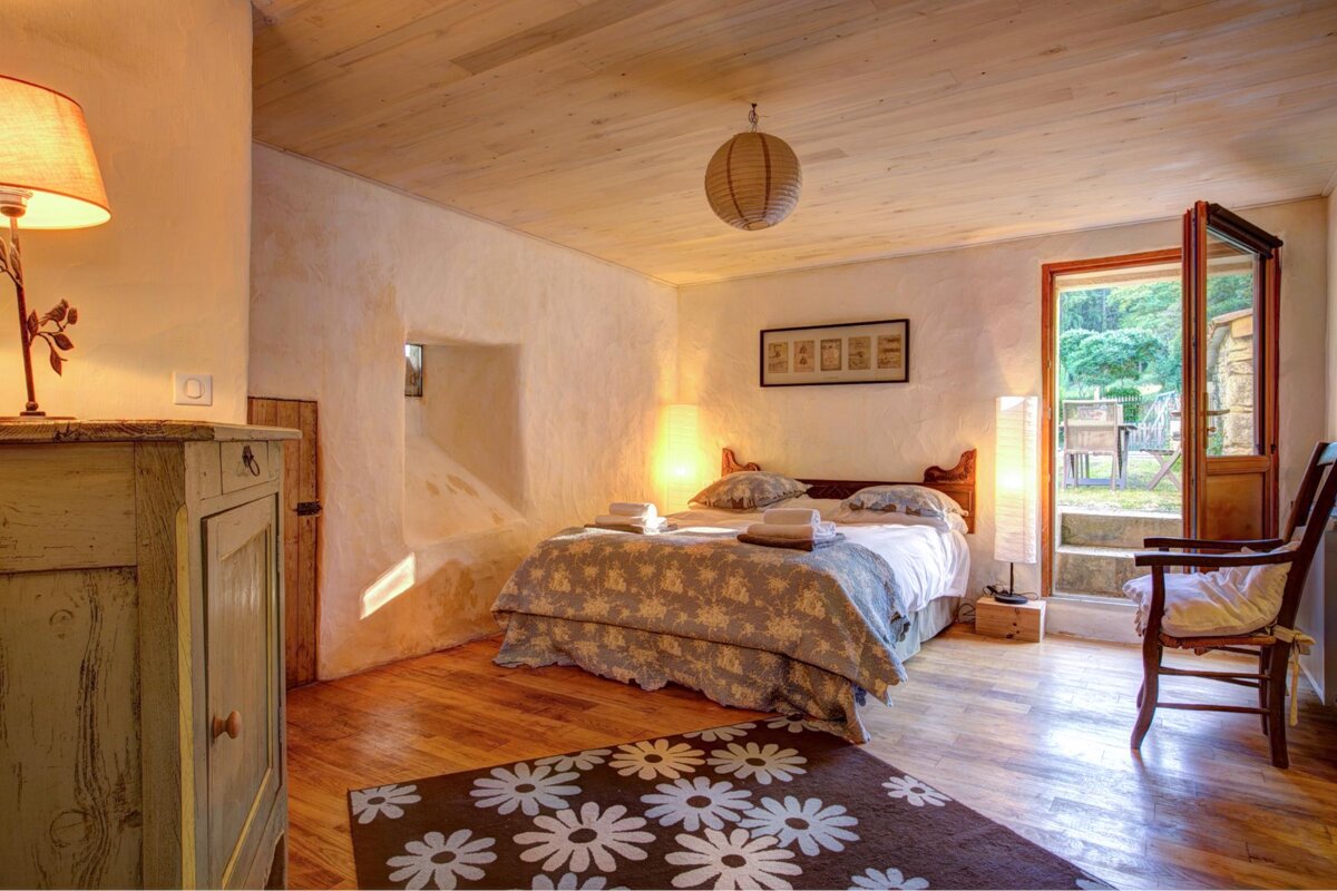 A bedroom with a bed and a rug with daisies on it