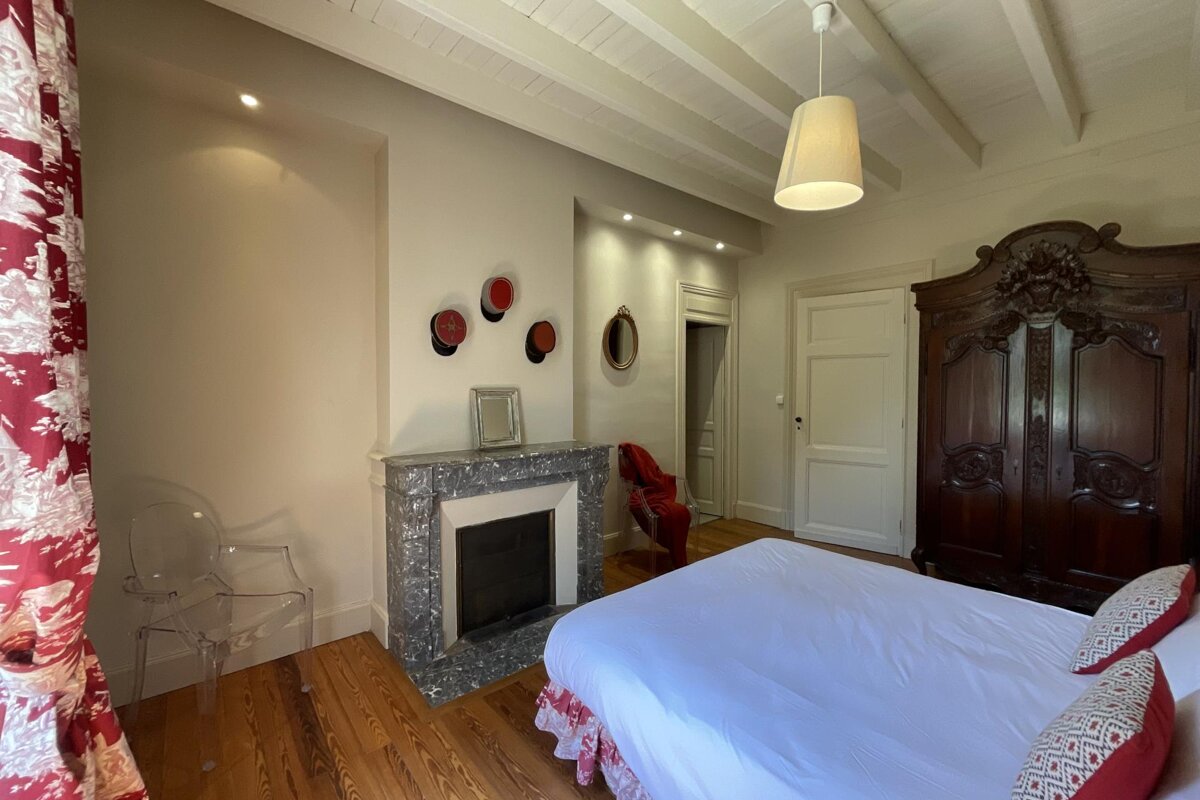 A bedroom with a fireplace and a bed