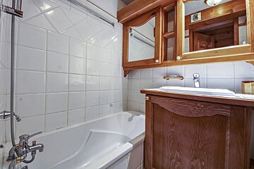 A bathroom with a bathtub a sink and a mirror