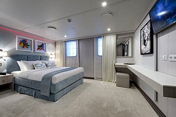 A bedroom with a large bed and a painting on the wall