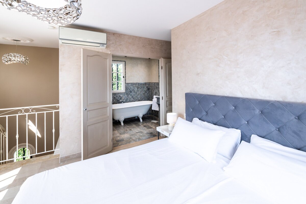 A bedroom with a claw foot tub in the bathroom