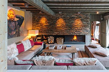 A living room with a fireplace and a painting on the wall that says 