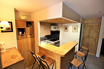 A kitchen with a wooden counter and stools