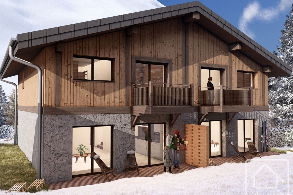 A two-story mountain chalet in winter, featuring a stone ground floor and wooden upper level.