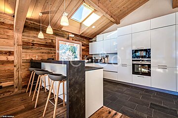 A kitchen with white cabinets and a skylight