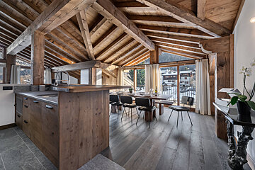 A bedroom with wood paneling and a bed with white sheets