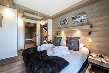 A bedroom with a large bed and a nightstand with a magazine on it
