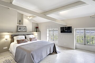 A bedroom with a large bed and a flat screen tv