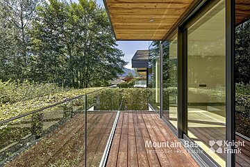 A balcony with a glass railing and the word mountain on it