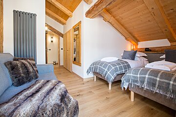 A bedroom with two beds and a couch