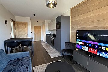 A living room with a flat screen tv and a couch