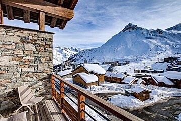 A view of a snowy mountain village from a balcony