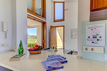 A kitchen counter with a bowl of fruit and a book on it