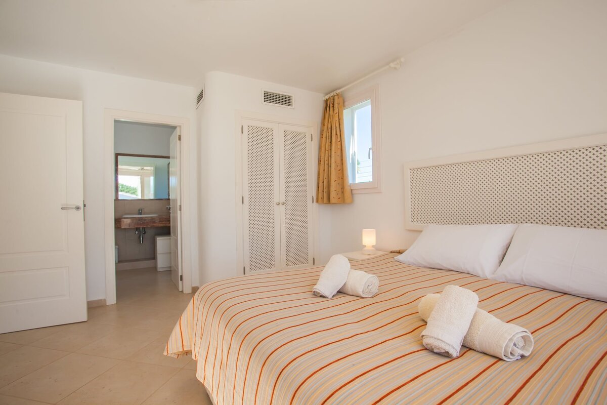 A bedroom with a striped bed and towels on it