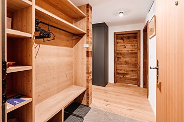 A hallway with wooden shelves and a wooden door