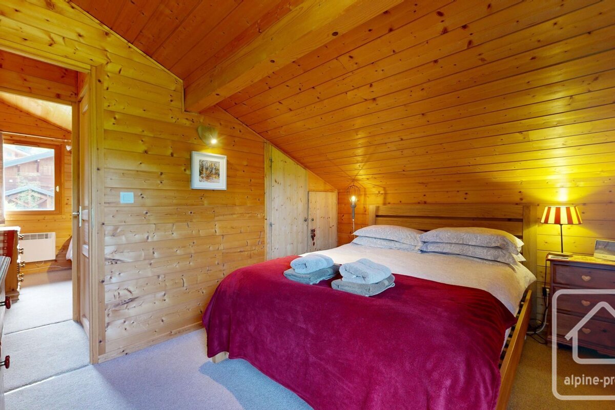 A bedroom with a bed and a picture on the wall that says alpine-pro