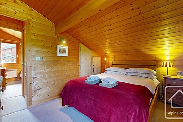A bedroom with a bed and a picture on the wall that says alpine-pro