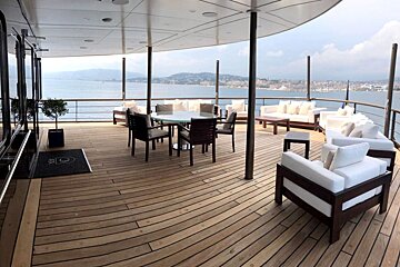 A large wooden deck with a table and chairs on it