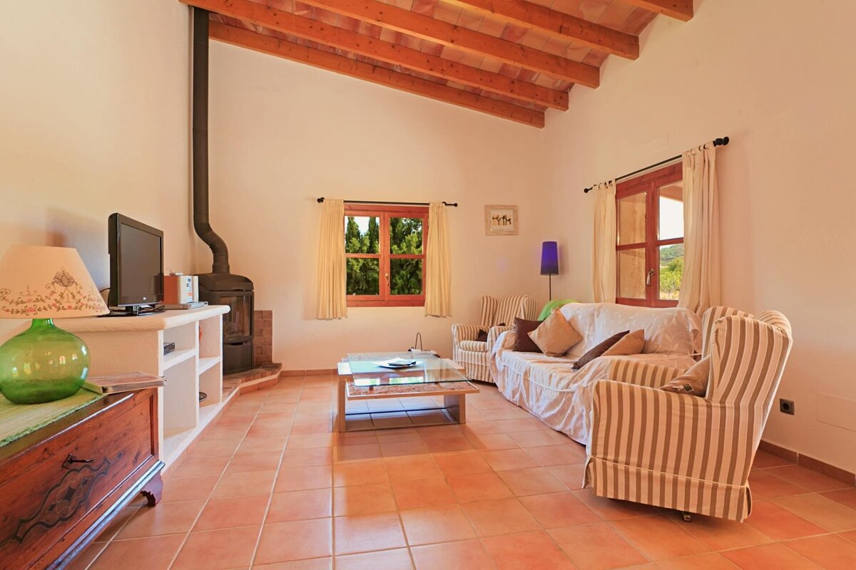 A living room with a couch and chairs and a television