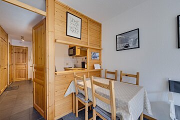 A kitchen with a table and chairs and a picture on the wall