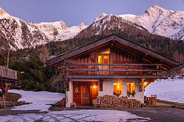 A house in the snow with mountains in the background